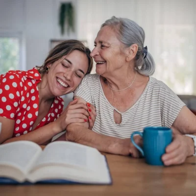 Hija y madre compartiendo un rato de lectura y café